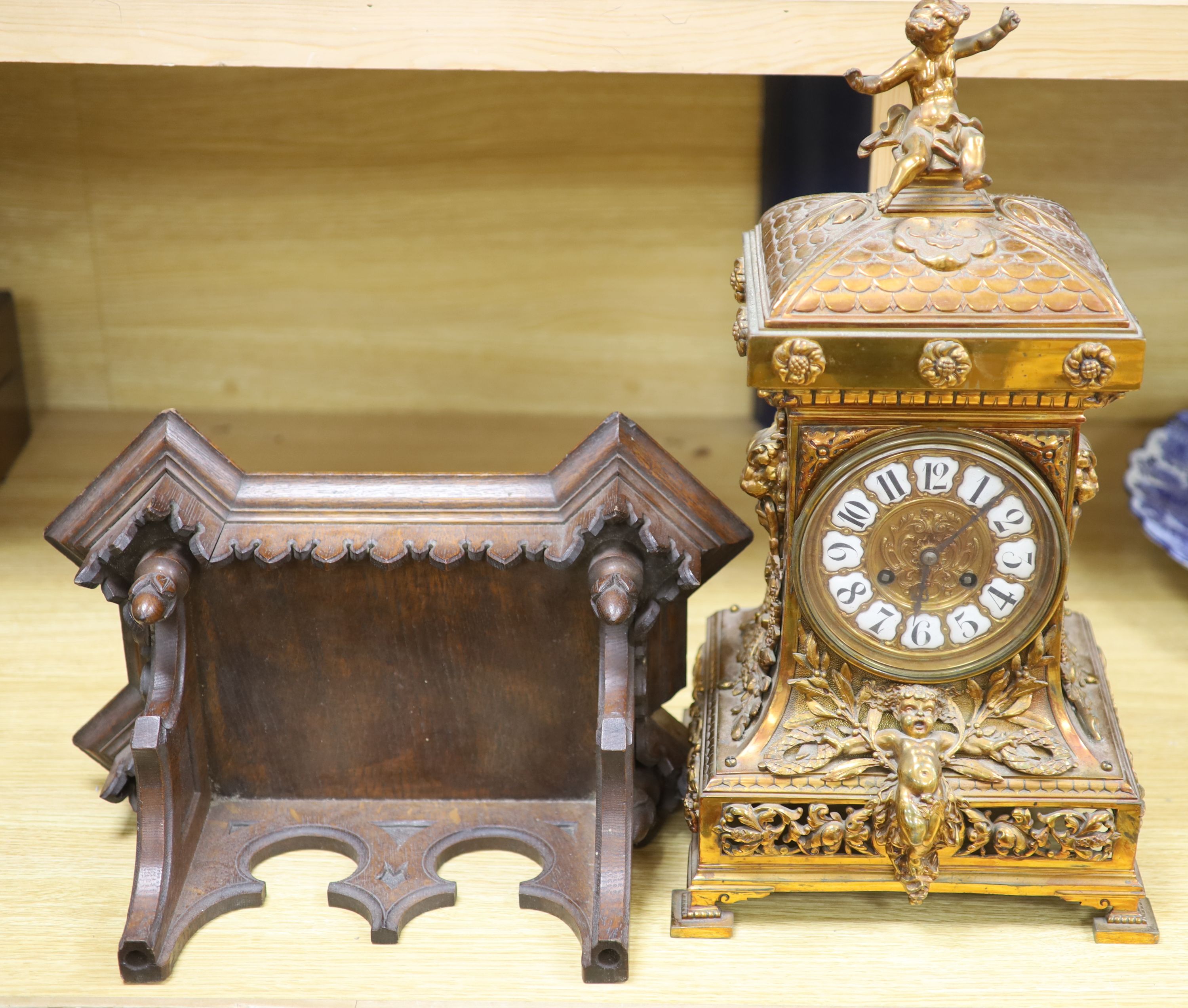 A late 19th century French cast brass cased eight day mantel clock and a carved oak clock bracket, height 50cm